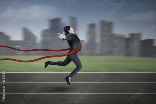 Businesswoman crossing the finish line © Creativa Images