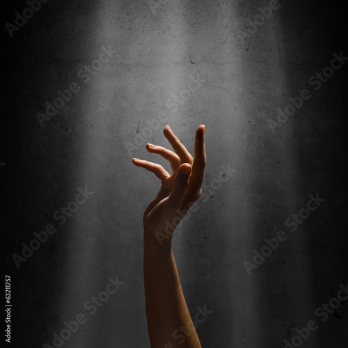 Obraz na plátně woman's hand reaches for the light rays