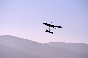 Fotobehang Luchtsport Paraglider glijdt over wolkendek  © krstrbrt