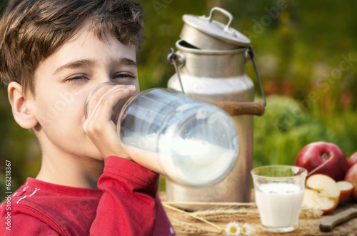 Junge trinkt frische Milch im Freien photo