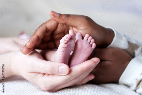Pieds de bébé entre les mains de ses parents