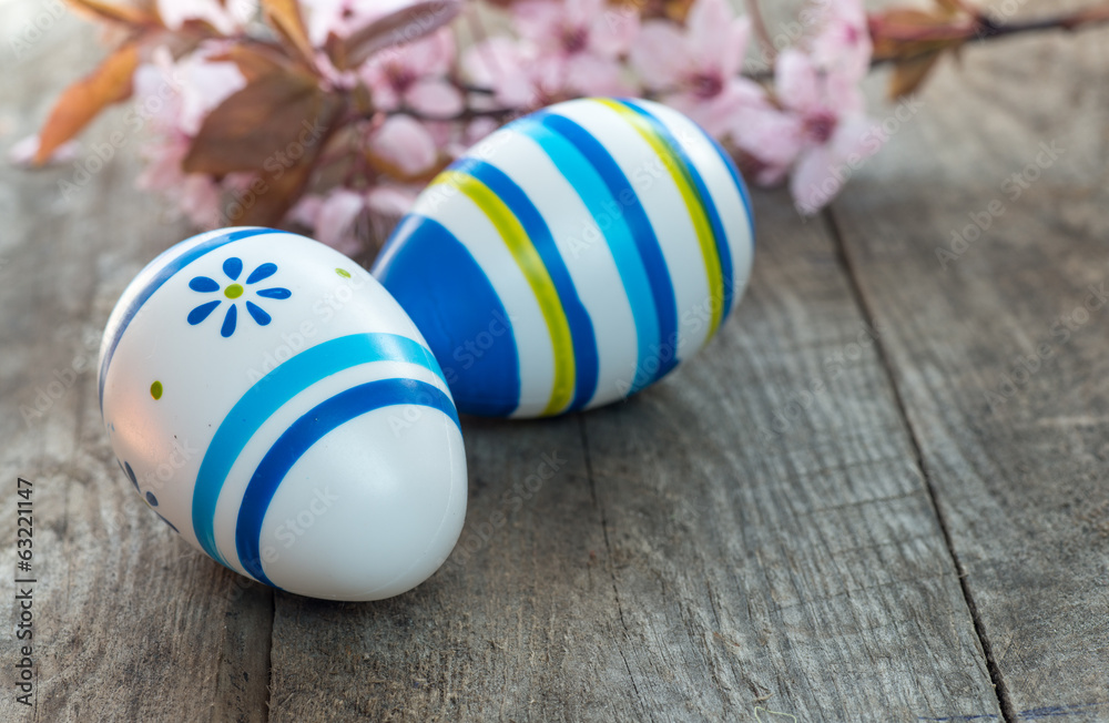 Fototapeta premium Colored Easter eggs and cherry blossom flowers