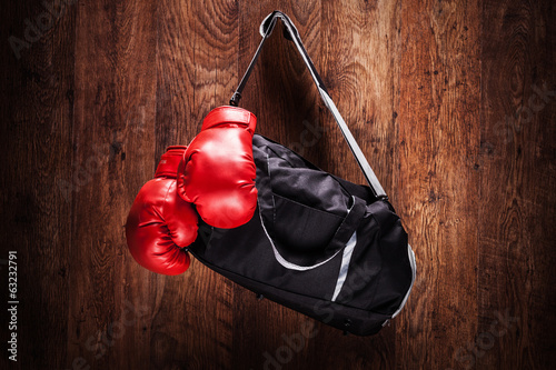 Sports bag and boxing gloves hanging on a wall