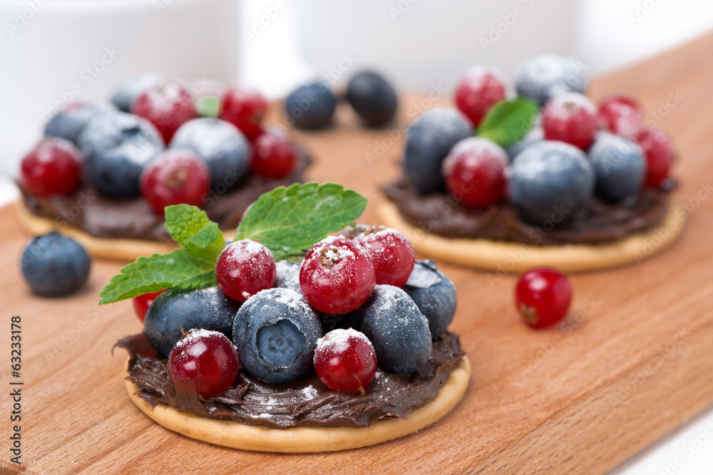cake with chocolate cream and berries on wooden board cake with chocolate cream and berries on wooden board