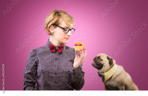 Pretty woman with a cake and her dog sitting by the table photo