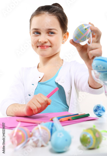 Wesoła dziewczynka maluje wielkanocne pisanki