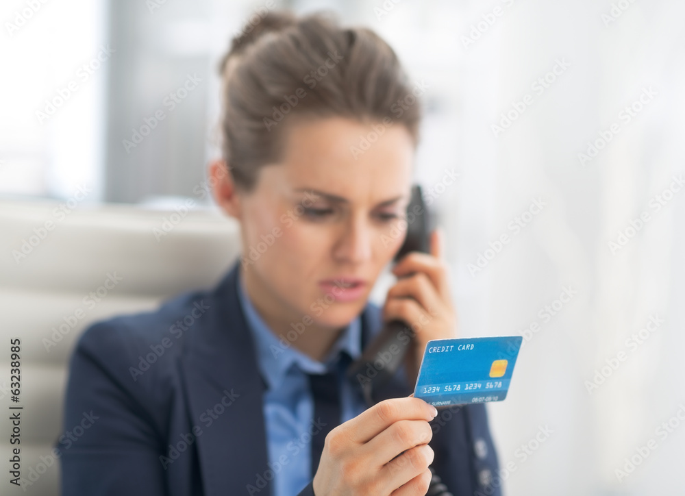 Closeup on business woman with credit card talking phone Closeup on business woman with credit card talking phone