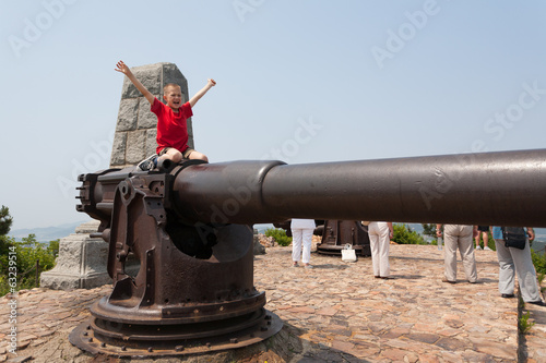 Boy on a gun in the old Russian fort photo
