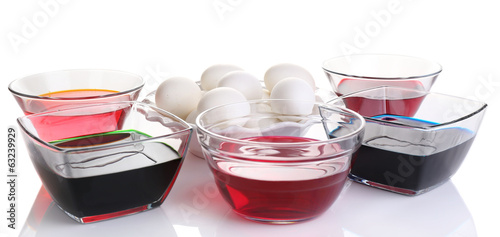 Eggs with liquid colour in glass bowls isolated on white