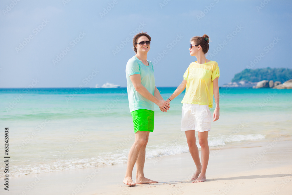 Young couple in bright clothes enjoying their time on tropical
