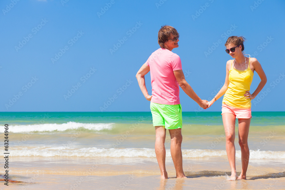 Couple in bright clothes on tropical beach in Thailand Couple in bright clothes on tropical beach in Thailand