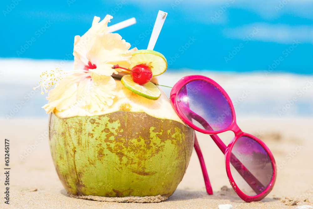 picture of fresh cocnut cocktail and red sunglasses on tropical