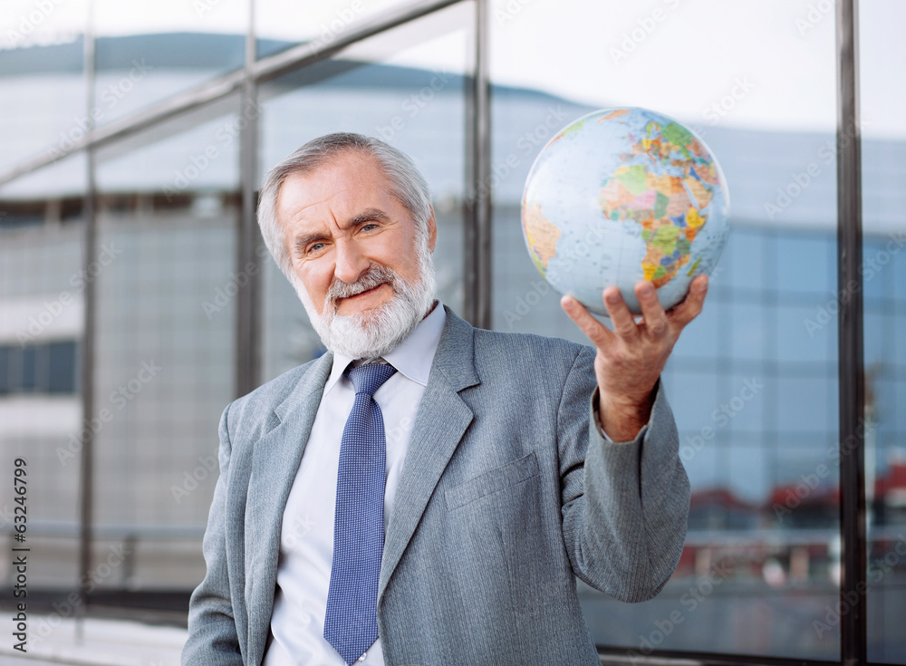 Senior businessman holding globe Senior businessman holding globe