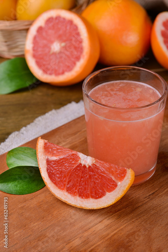 Ripe grapefruit with juice on table close-up