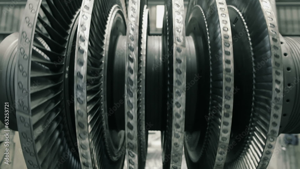 frontal shot of spinning steam turbine at workshop