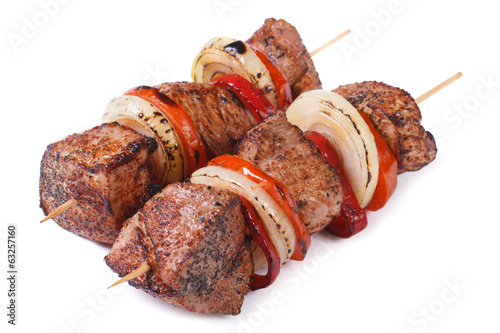 two skewers of meat with vegetables isolated on a white photo