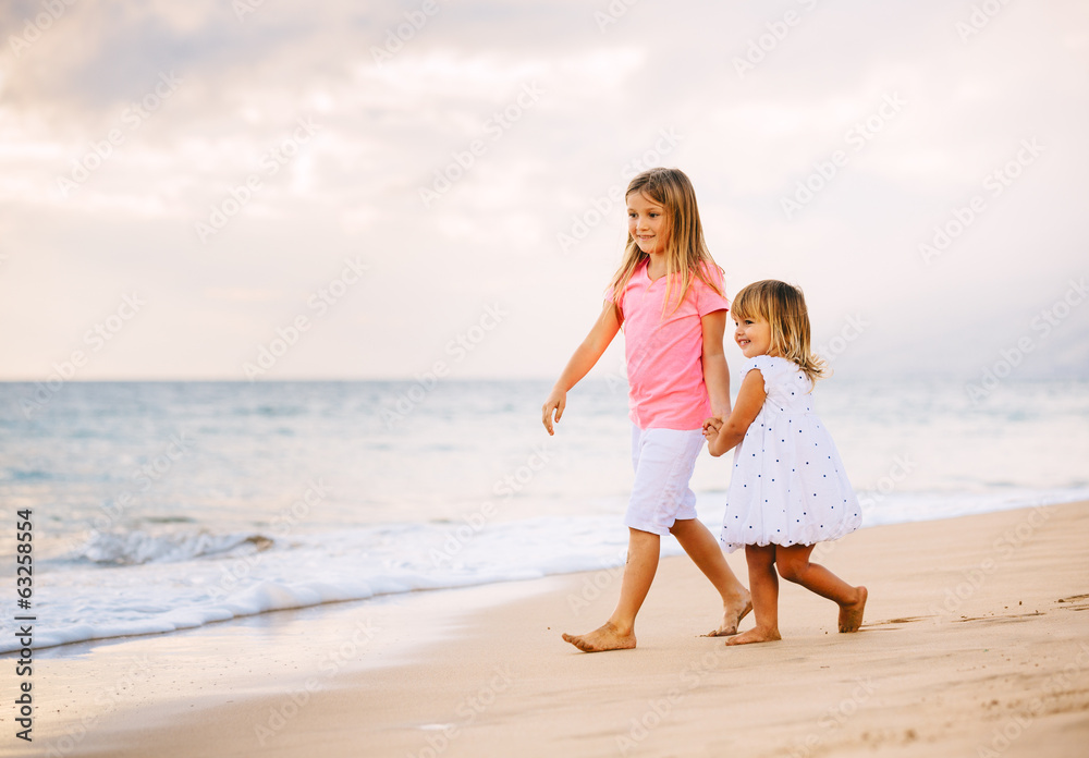 Two Little Girls Walking together on the Beach at Sunet Two Little Girls Walking together on the Beach at Sunet
