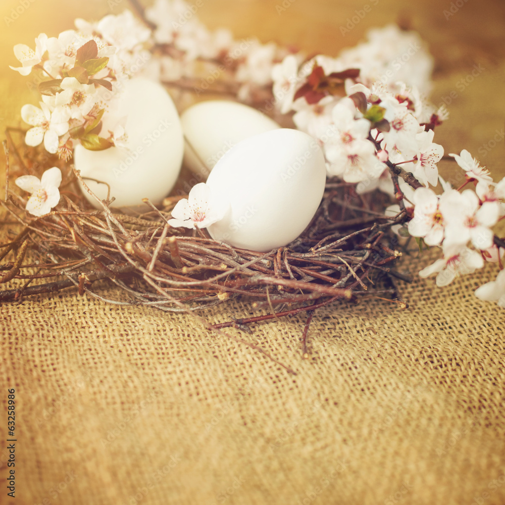 Nest with white Easter eggs and beautiful Spring flowers