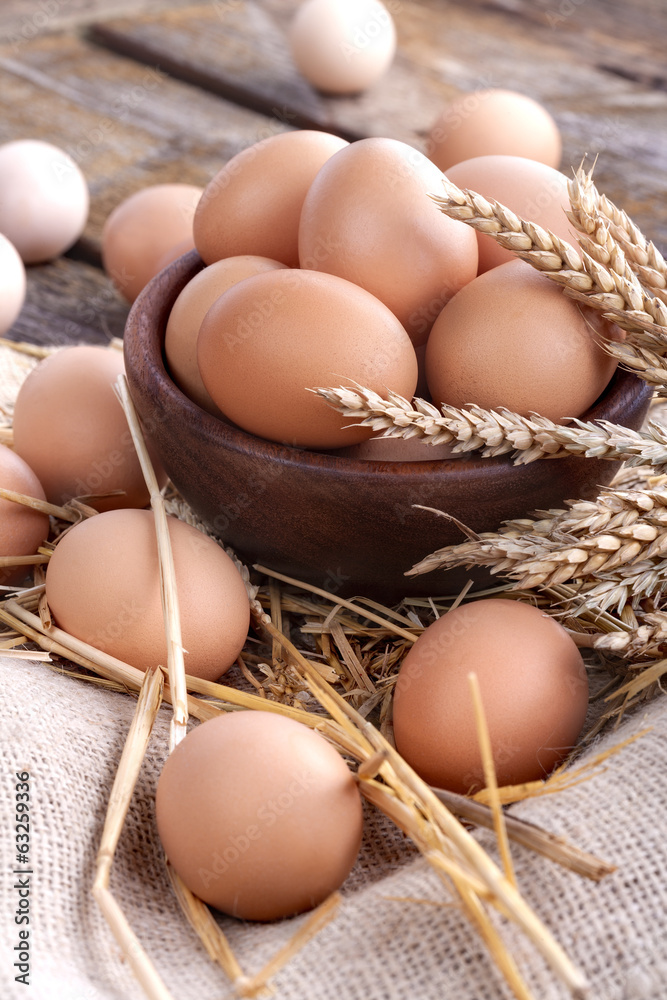 Healthy domestic eggs in a wooden bowl on a rustic table