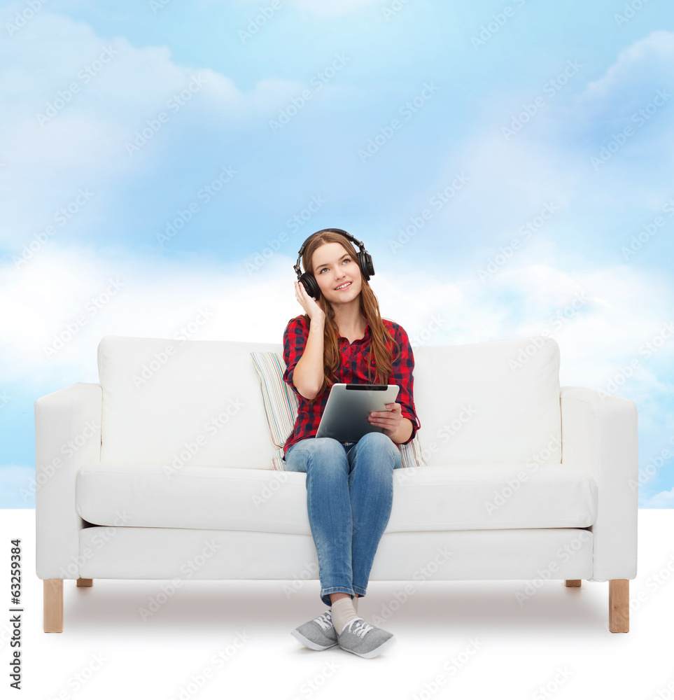 girl sitting on sofa with headphones and tablet pc girl sitting on sofa with headphones and tablet pc