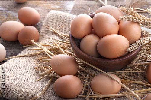 Healthy domestic eggs in a wooden bowl on a rustic table