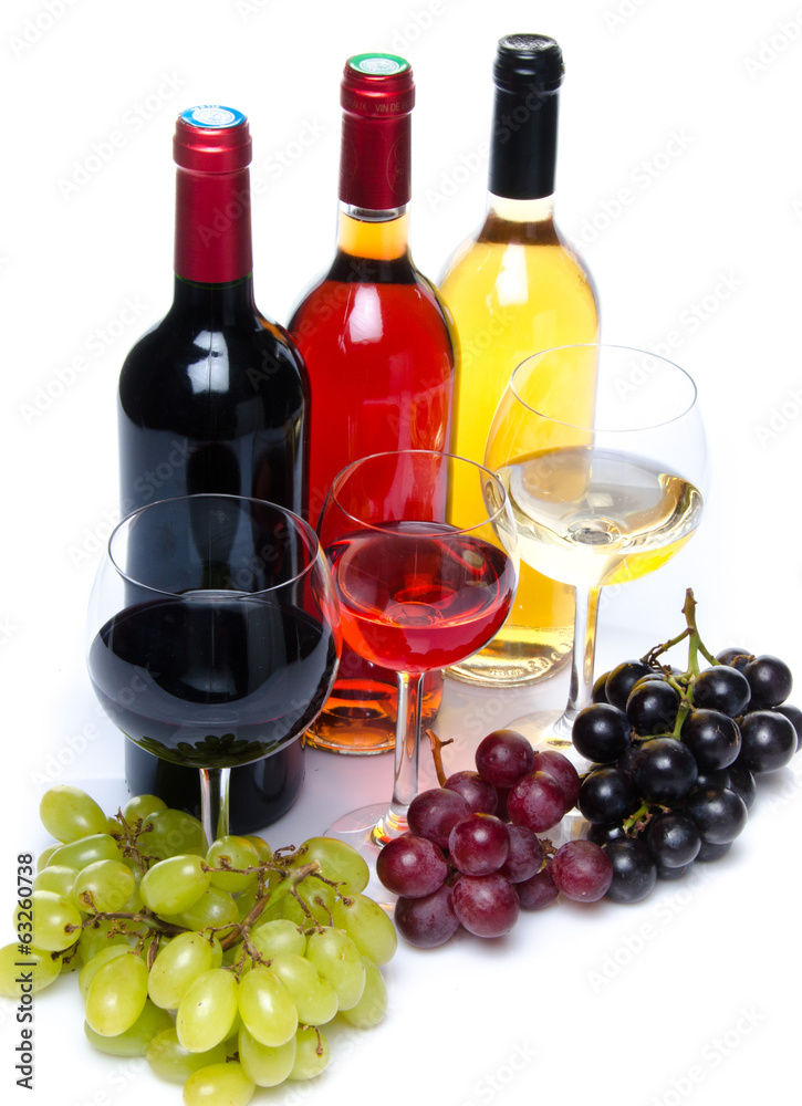 Bootles and glasses of wine with black, red and white grapes