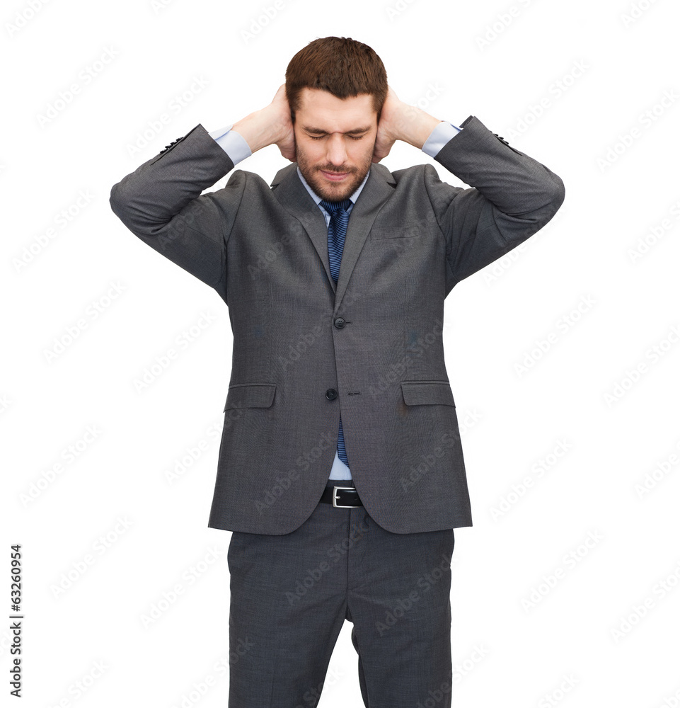 annoyed businessman covering ears with his hands annoyed businessman covering ears with his hands