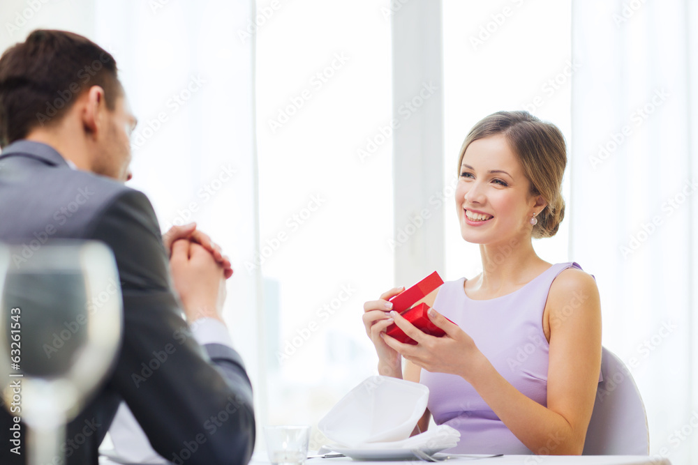 excited young woman looking at boyfriend with box excited young woman looking at boyfriend with box