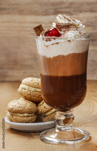 Irish coffee and stack of cookies on wooden table