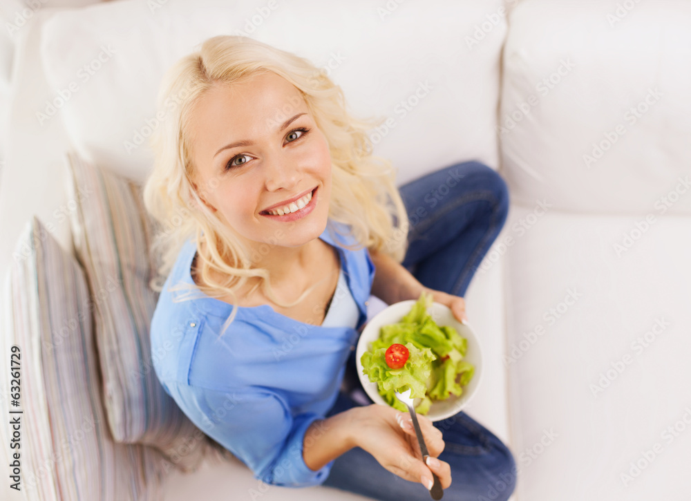 smiling young woman with green salad at home smiling young woman with green salad at home
