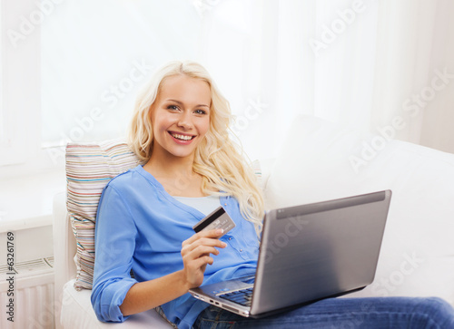 smiling woman with laptop computer and credit card