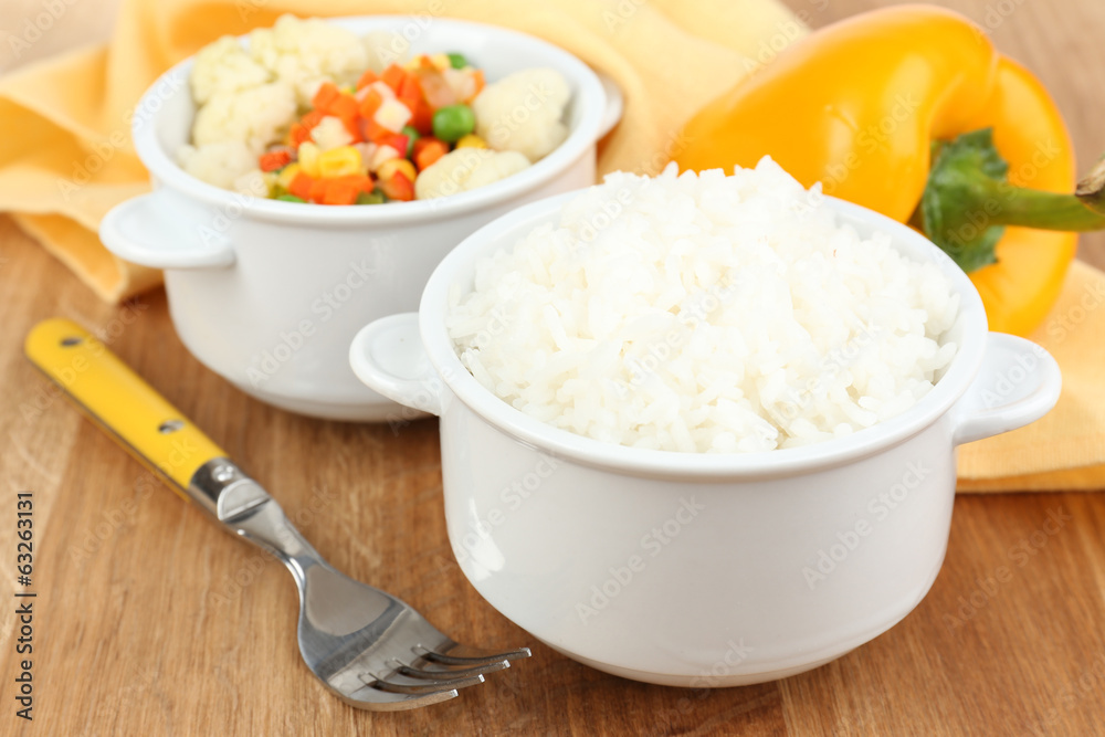 Cooked rice with vegetables on wooden table close up Cooked rice with vegetables on wooden table close up
