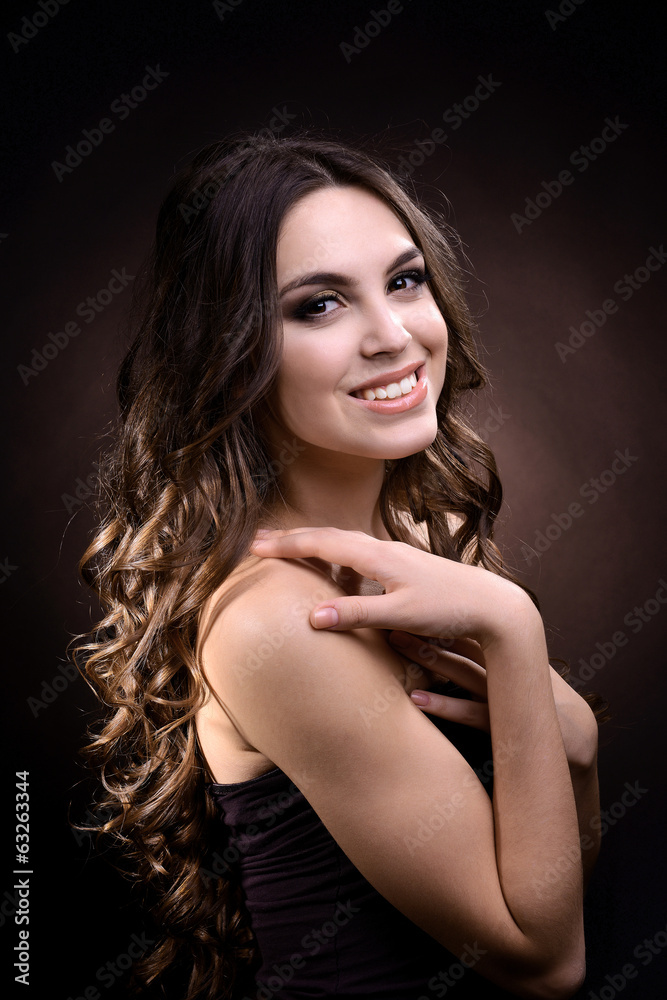 Beautiful young woman with long hair on dark brown background Beautiful young woman with long hair on dark brown background