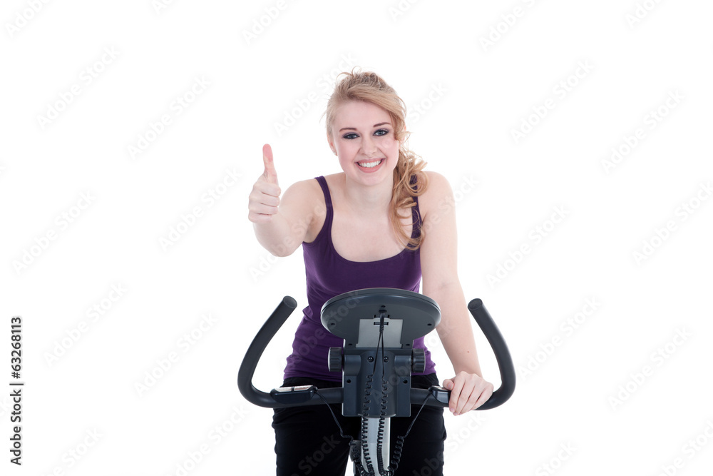 Sportliche Frau mit Heimtrainer zeigt Daumen hoch Porträt Sportliche Frau mit Heimtrainer zeigt Daumen hoch Porträt