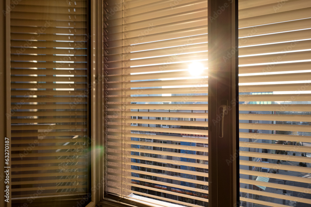 Jalousien als Sonnenschutz am Fenster