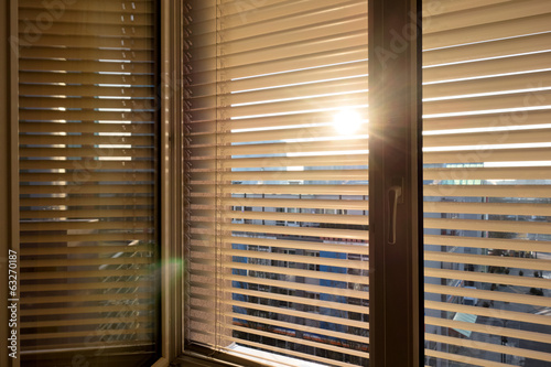 Jalousien als Sonnenschutz am Fenster photo