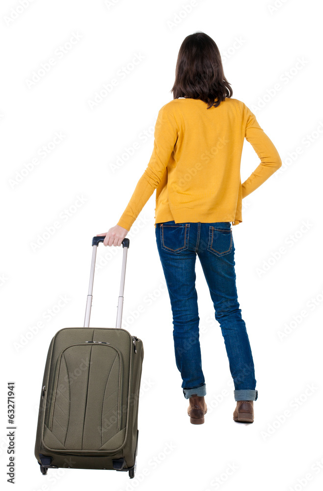 back view of walking woman in cardigan with suitcase. back view of walking woman in cardigan with suitcase.