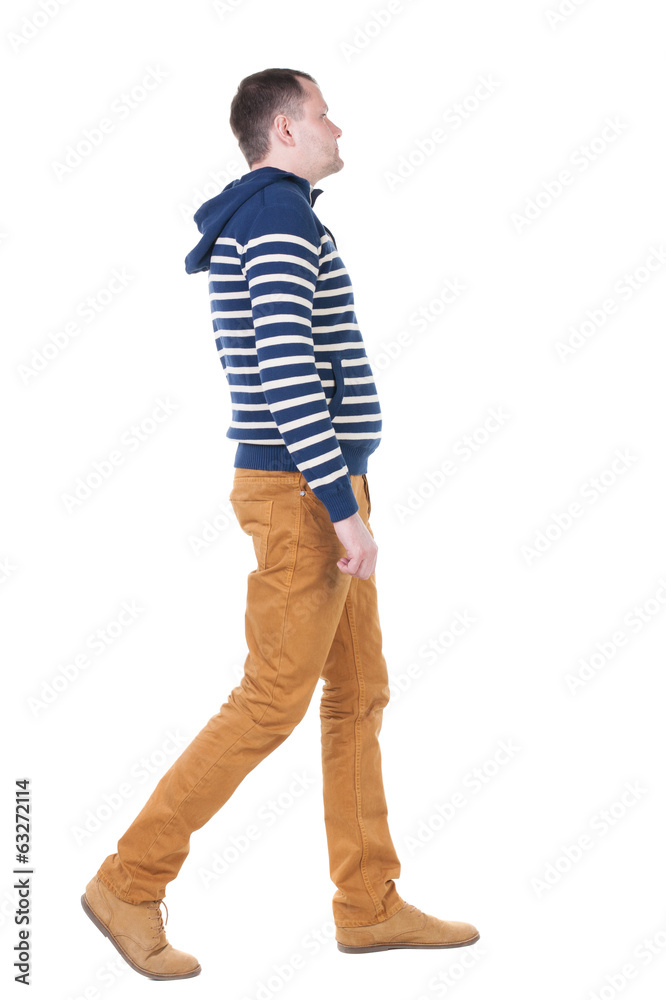 Back view of walking handsome man in jeans and striped sweater. Back view of walking handsome man in jeans and striped sweater.