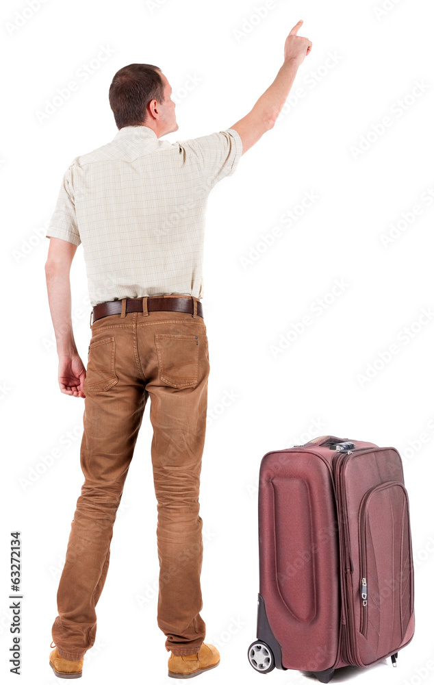 Back view of pointing young men traveling with suitcas . Back view of pointing young men traveling with suitcas .