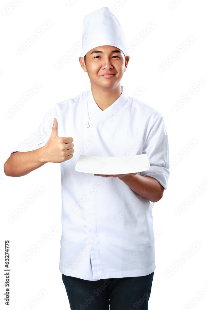 Young cook keeps an empty plate with thumb up Young cook keeps an empty plate with thumb up