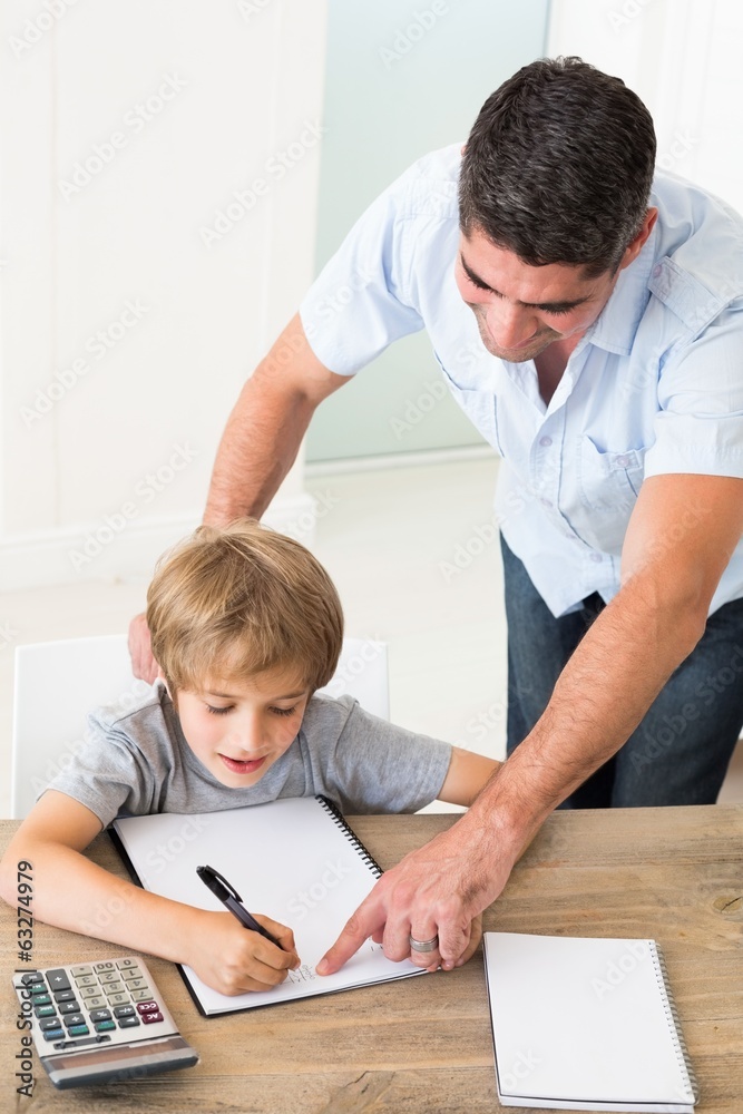 Naklejka premium Father assisting boy in solving maths