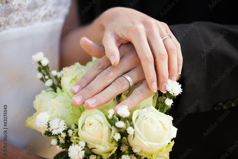 Newlywed couple with wedding rings and bouquet Newlywed couple with wedding rings and bouquet