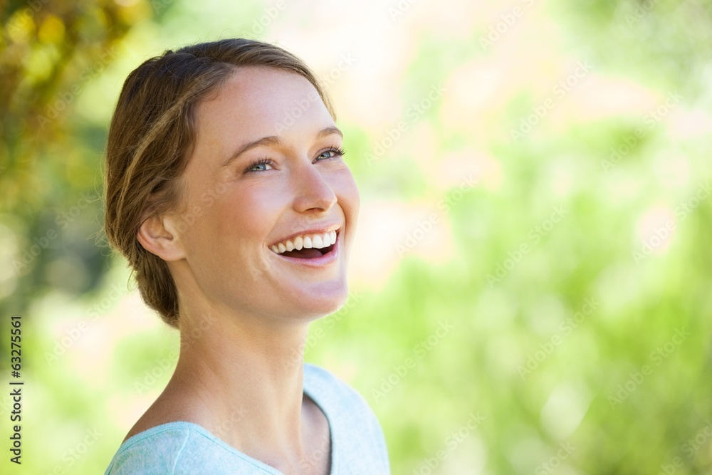 Cheerful thoughtful woman looking away in park Cheerful thoughtful woman looking away in park