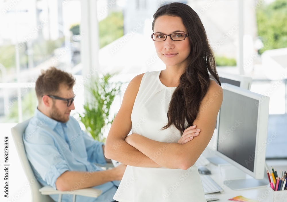 Pretty designer looking at camera leaning on desk Pretty designer looking at camera leaning on desk