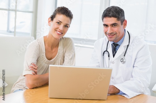 Doctor and patient using laptop in medical office