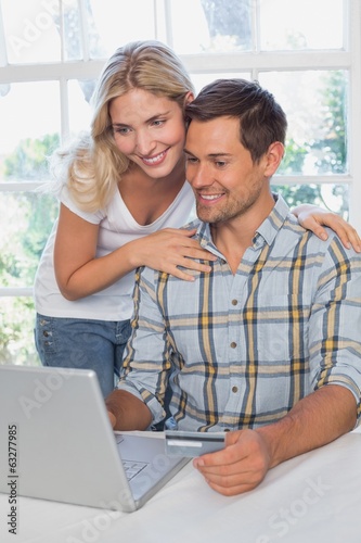 Happy couple doing online shopping at home