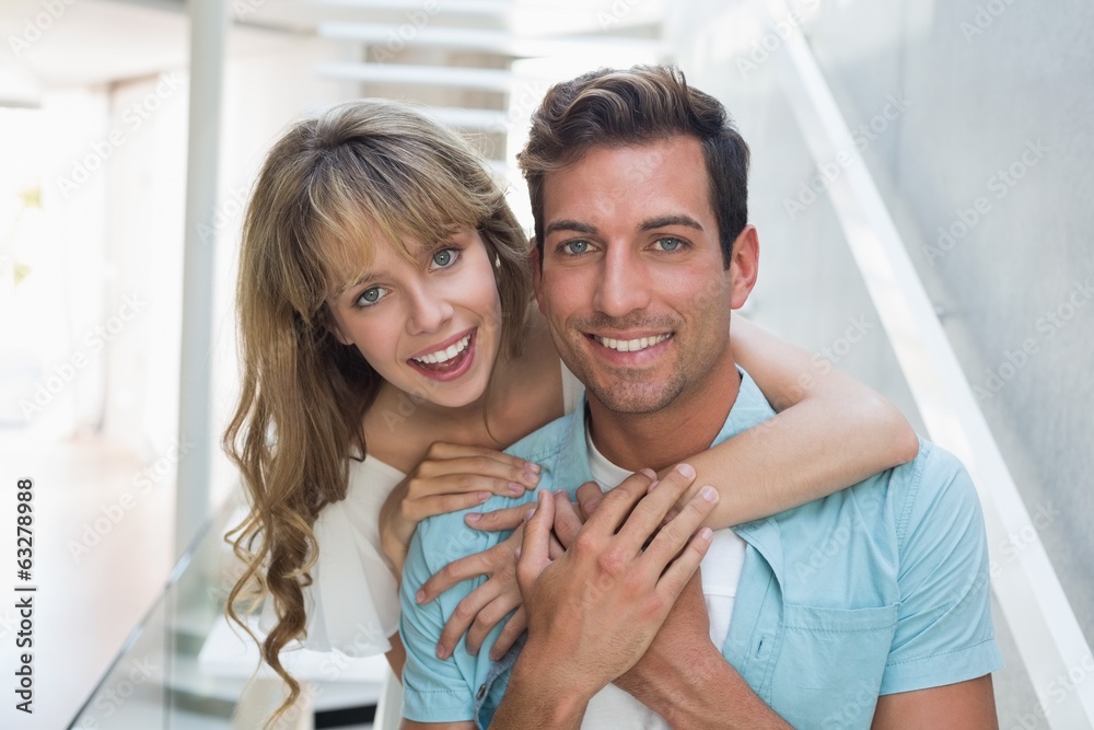 Loving woman embracing man from behind Loving woman embracing man from behind