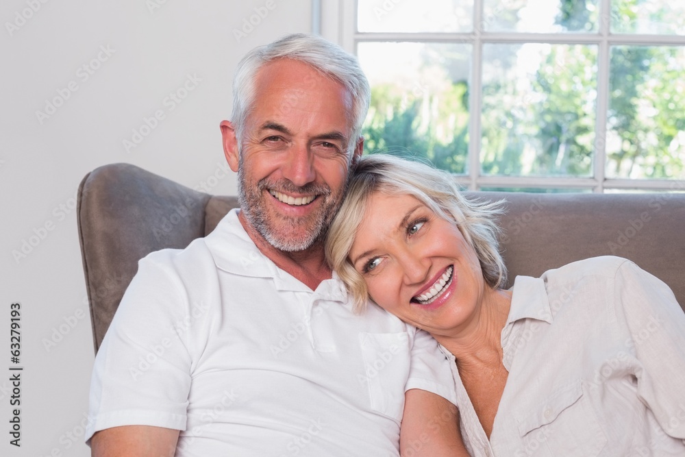 Portrait of a smiling mature couple sitting on sofa Portrait of a smiling mature couple sitting on sofa