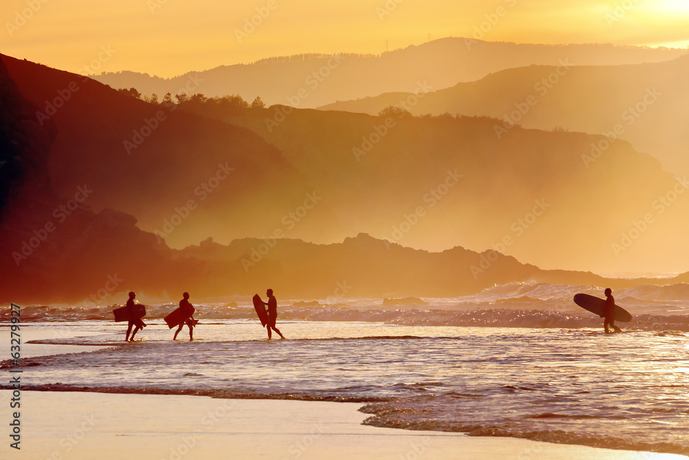 Fototapeta premium surfers and boogie boards at sunset
