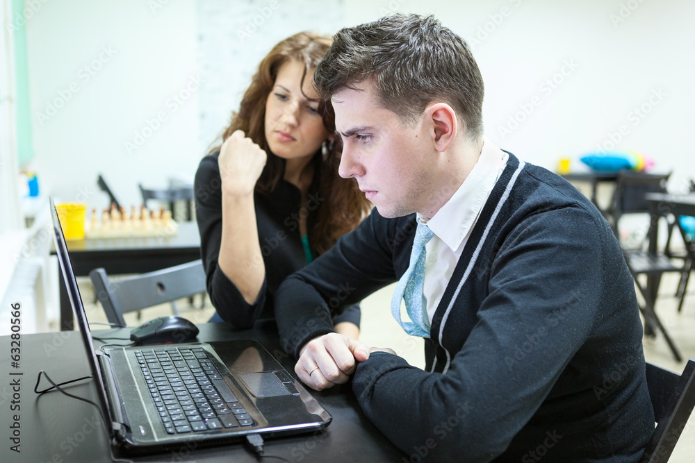 Young couple reading some text on laptop screen Young couple reading some text on laptop screen